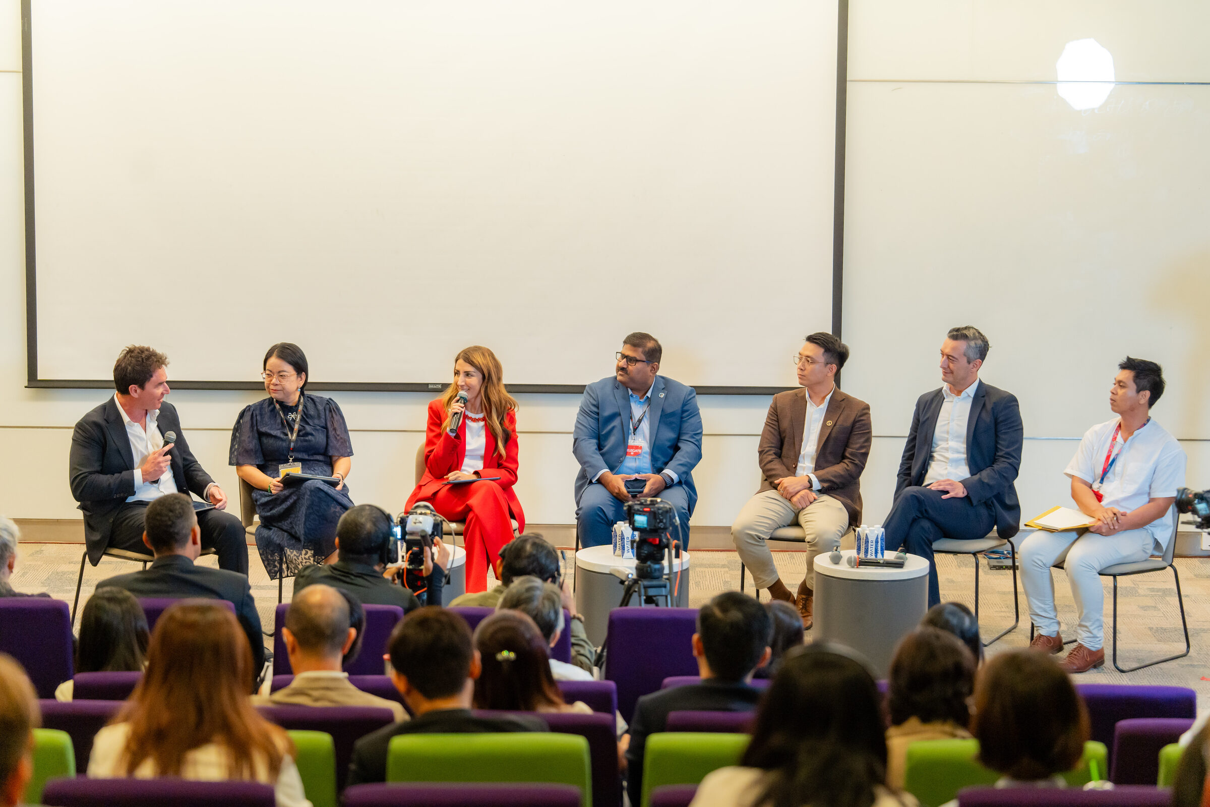 Nick McIntosh moderating the seven-person Nobel Prize Dialogue panel